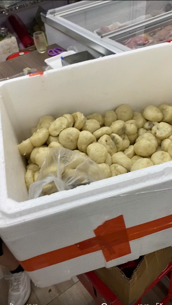 Thùng bánh bao chiên ăn liền không che đậy, không rõ cơ sở sản xuất đặt cạnh tủ bảo quản bán các sản phẩm tươi sống