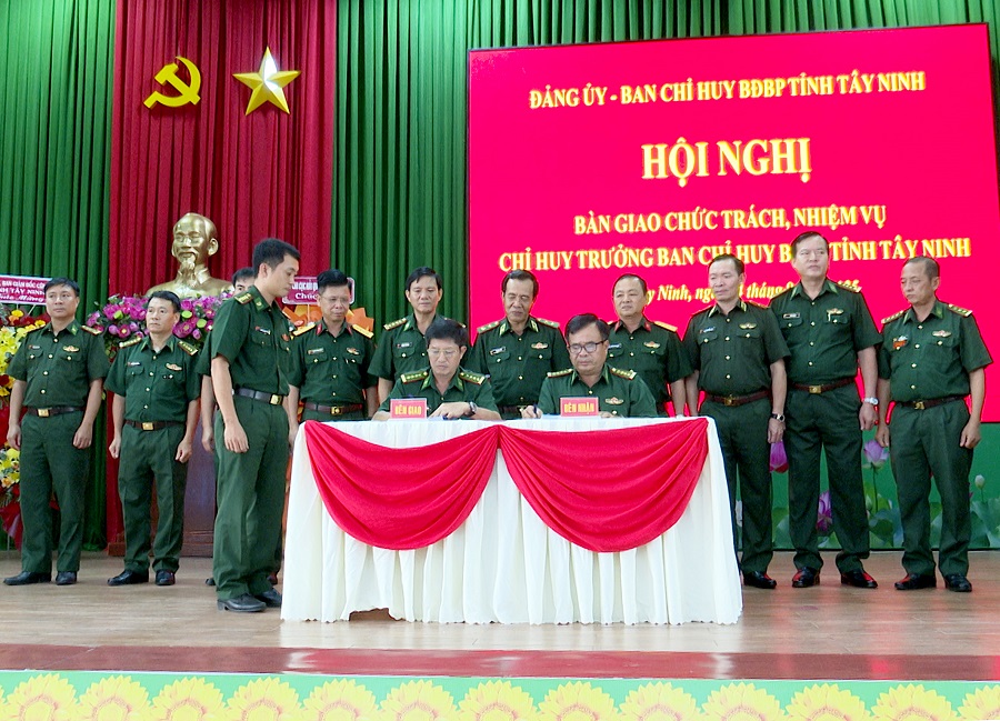Đại tá Đàm Quang Ngoạt và Đại tá Phạm Văn Cờ ký biên bản giao-nhận chức trách, nhiệm vụ, dưới sự chứng kiến của Trung tướng Lê Đức Thái và đoàn công tác Bộ Tư lệnh BĐBP