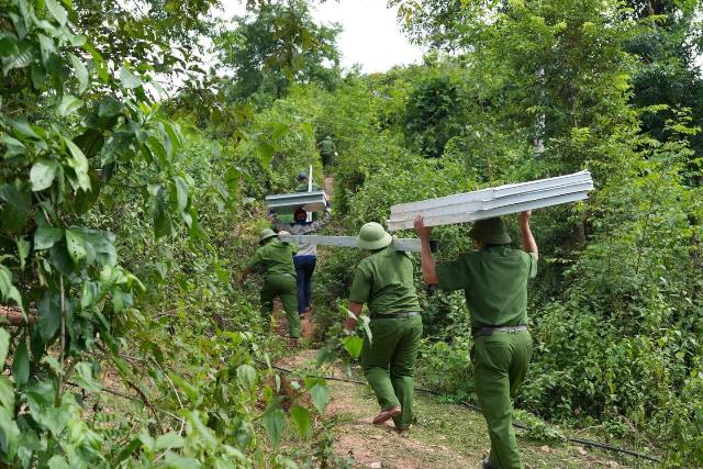 Công an xã Mường Típ vượt đồi vận chuyển vật liệu dựng nhà cho bà con bản Ta Đo.