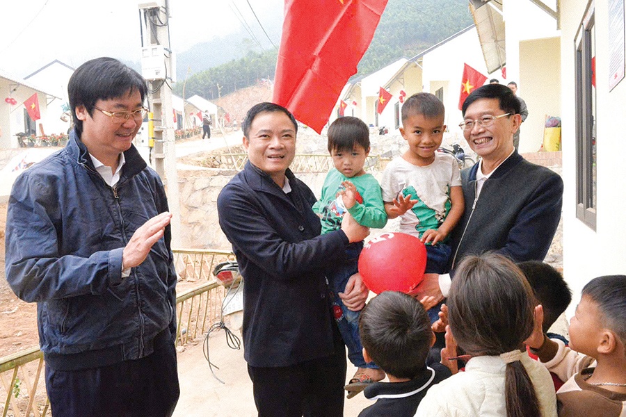 Đồng chí Lê Ngọc Sơn và đồng chí Trần Quang Dũng, Phó Bí thư thường trực Đảng ủy Tập đoàn thăm hỏi đồng bào và các cháu thiếu nhi tại khu tái thiết thôn Kho Vàng