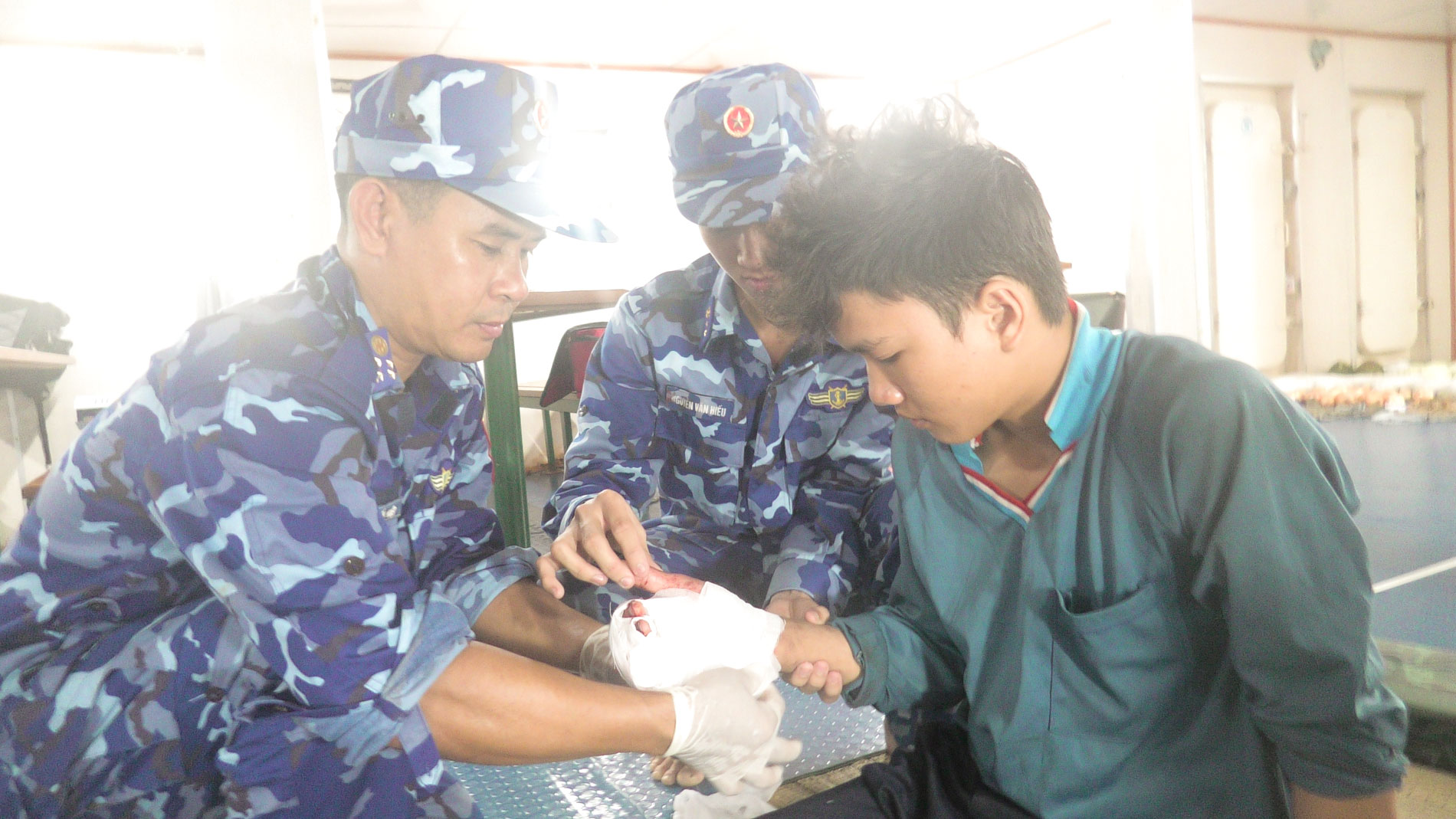 Cán bộ, chiến sĩ tàu CSB 6003 tiến hành sơ cứu vết thương cho thuyền viên Trần Văn Đạt.