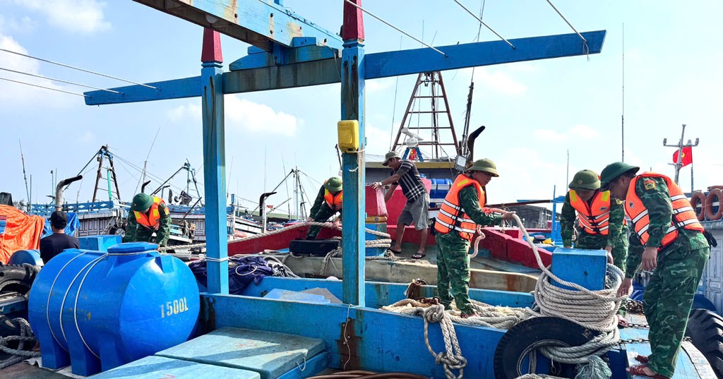 Cán bộ, chiến sĩ Đồn Biên phòng Ngọc Lâm (BĐBP tỉnh Ninh Bình) giúp ngư dân chằng chống tàu thuyền.