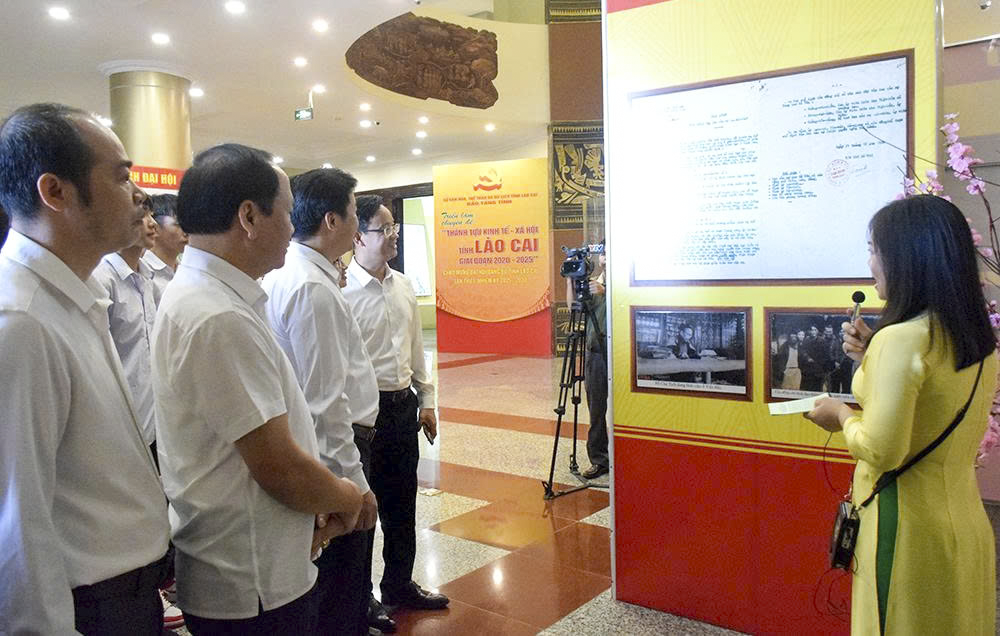 Các đại biểu thăm quan và nghe thuyết minh về hình ảnh và tư liệu được trưng bày tại Triển lãm