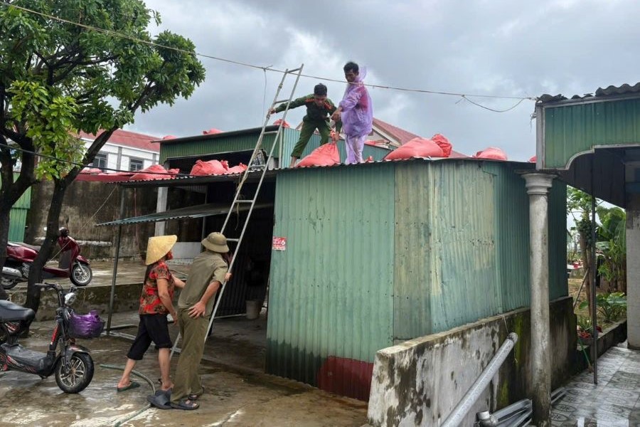 Lực lượng Công an giúp đỡ nhân dân gia cố, chằng chống nhà cửa trước khi bão đổ bộ.