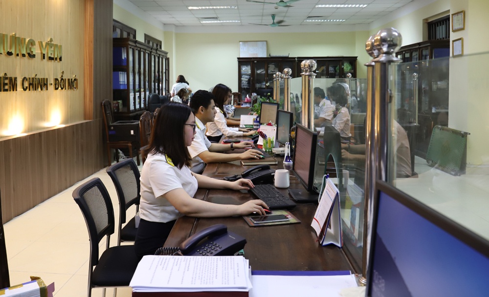 Công chức Thuế tỉnh Hưng Yên hướng dẫn người dân làm thủ tục nộp thuế. Ảnh: Hồ Huệ