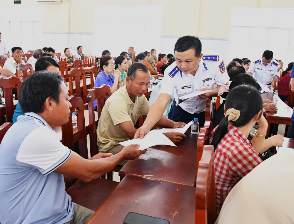 Phát tờ rơi tuyên truyền cho ngư dân.