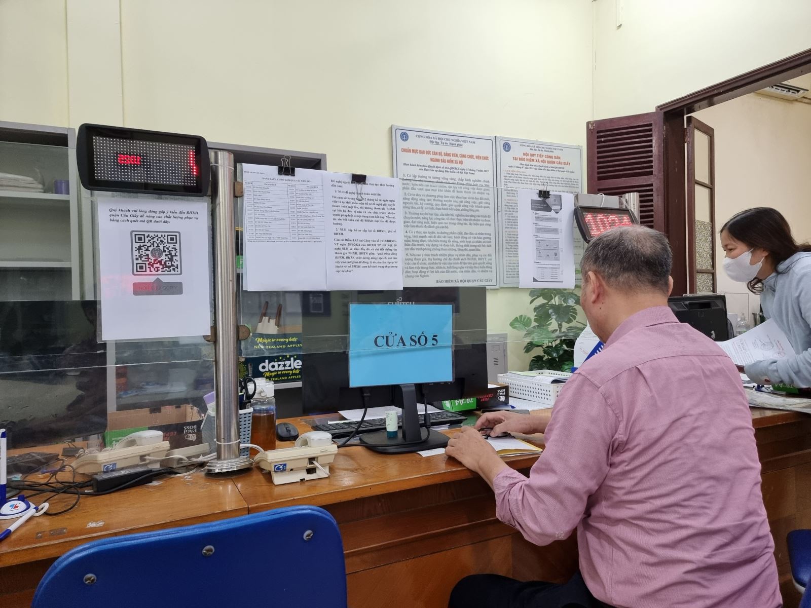 Làm thủ tục nhận lương hưu qua tài khoản. Ảnh: XC