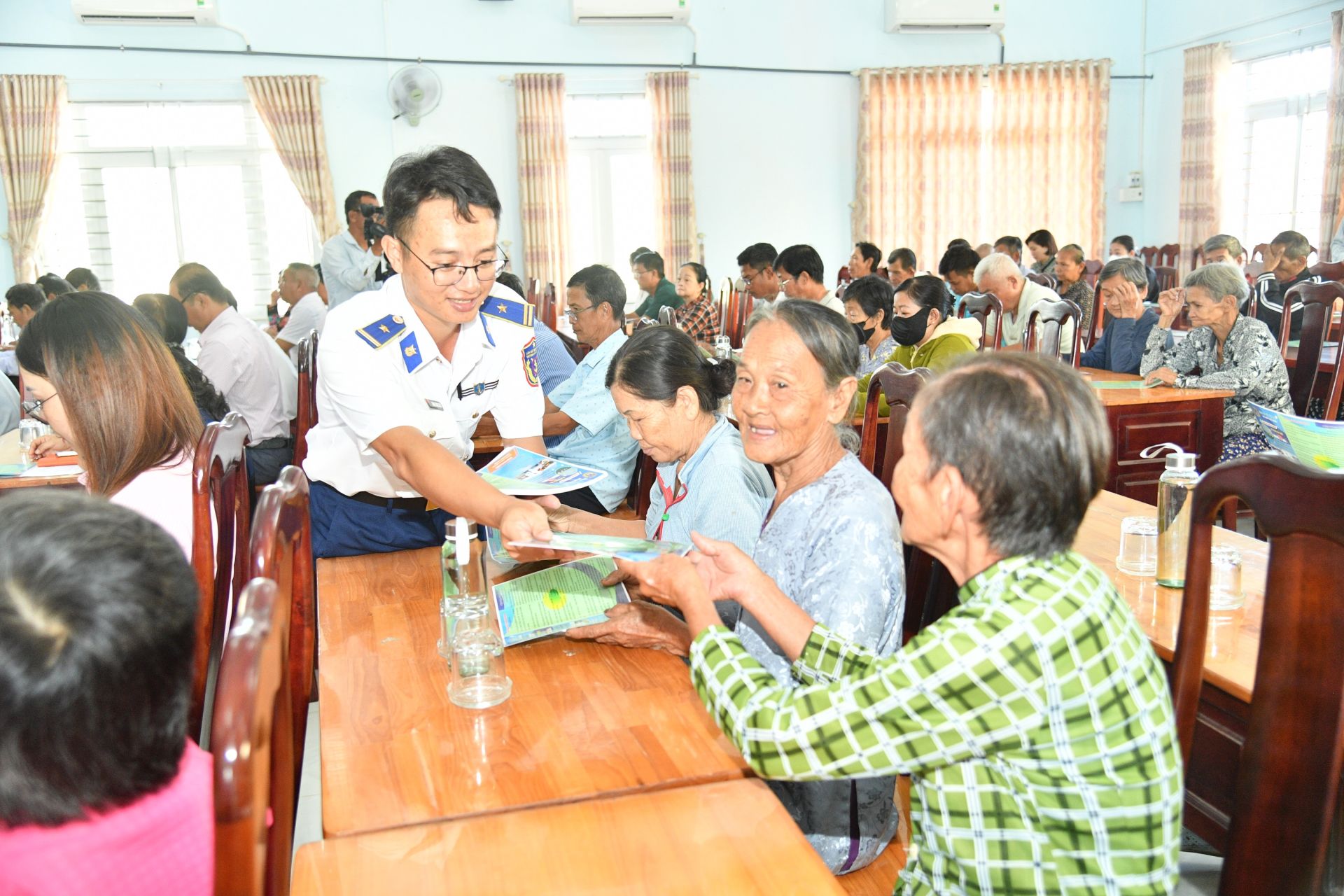 Cán bộ Bộ Tư lệnh Vùng Cảnh sát biển 4 phát tờ rơi tuyên truyền cho bà con ngư dân.