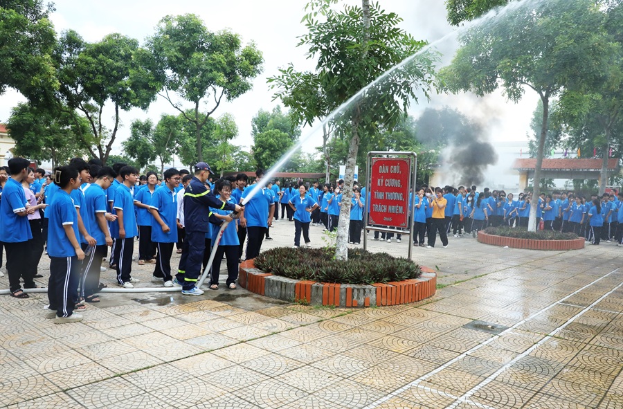 Các em học sinh trải nghiệm phun nước cứu hỏa