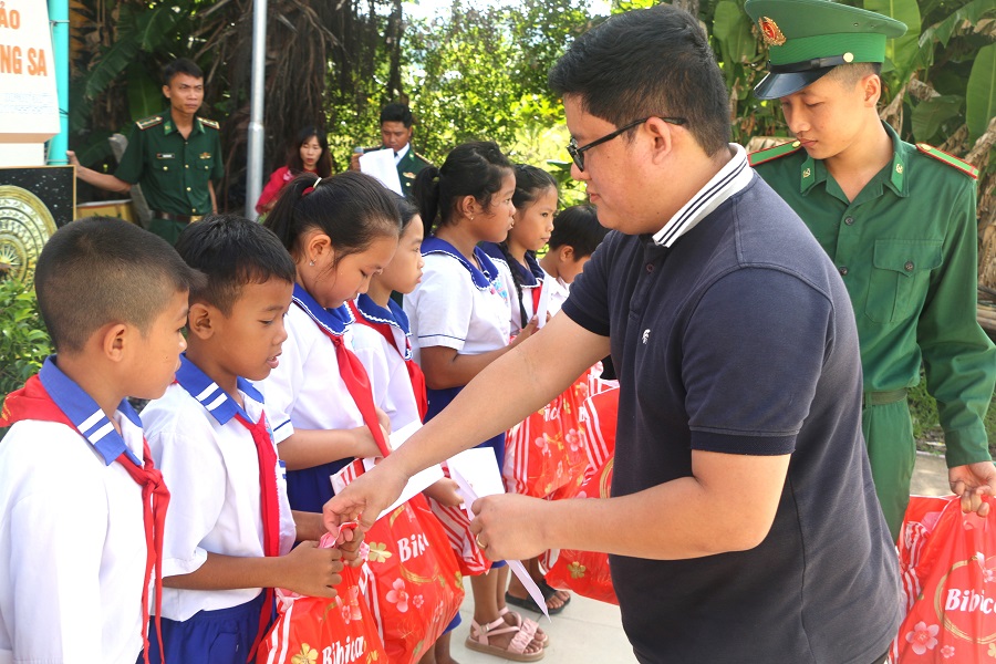 Ông Hồ Đông - Trưởng đại diện Tạp chí Thương hiệu và Công luận tại TP.HCM trao quà cho các em học sinh