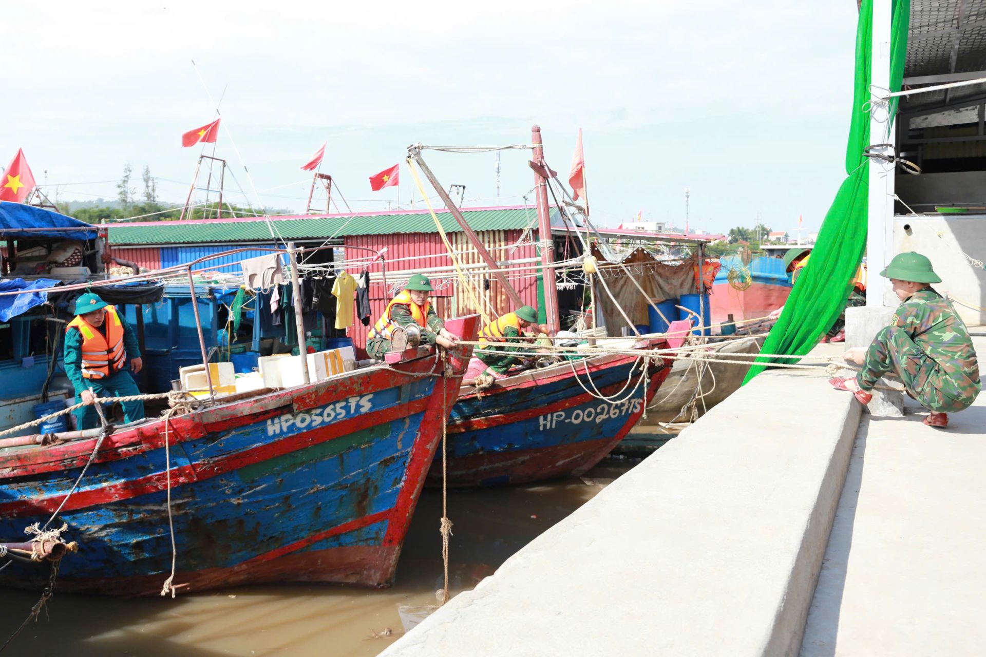 Cán bộ, chiến sĩ Bộ CHQS TP Hải Phòng giúp Nhân dân đưa tàu thuyền về nơi tránh, trú bão tại Cảng cá Ngọc Hải.