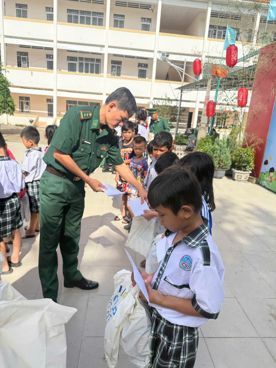 Trung tá Nguyễn Văn Phát Anh, Chính Trị viên Đồn Biên phòng Cửa khẩu Quốc tế Tịnh Biên trao quà cho các En học sinh