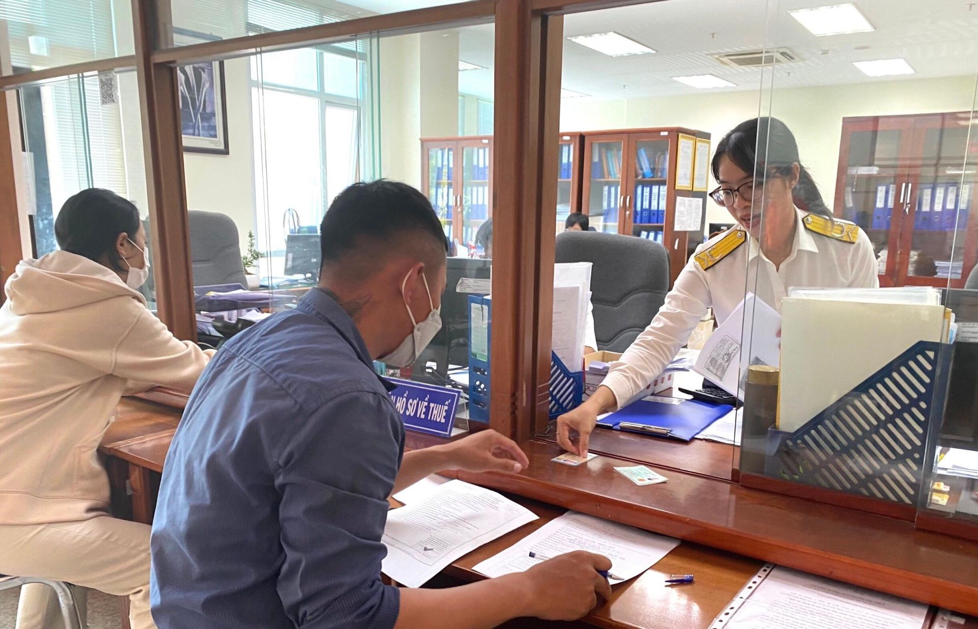 Công chức Thuế tỉnh Khánh Hòa hỗ trợ người dân làm thủ tục nộp thuế. Ảnh: C. Vân