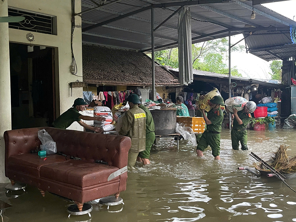 Cán bộ Công an xã Quang Trung hỗ trợ người dân di dời tài sản.