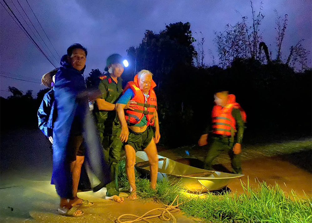 Cán bộ Công an xã Xuân Lương hỗ trợ người cao tuổi di chuyển đến nơi an toàn ngay trong đêm 6/10.