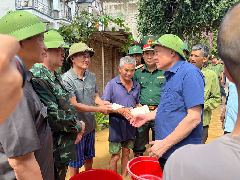 Phó Thủ tướng Thường trực Chính phủ Nguyễn Hoà Bình tặng quà cho người dân bị ảnh hưởng do ngập lụt tại xã Tiên Lục.