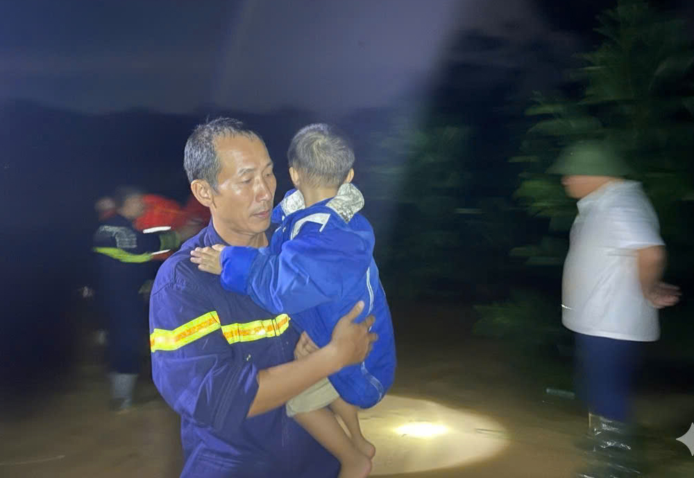 Lực lượng chức năng đưa trẻ em ra khỏi vùng nguy hiểm an toàn.