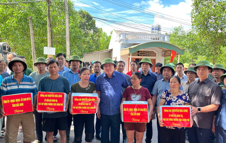 Phó Thủ tướng Thường trực Chính phủ Nguyễn Hoà Bình tặng quà cho người dân vùng lũ lụt xã Yên Thế.