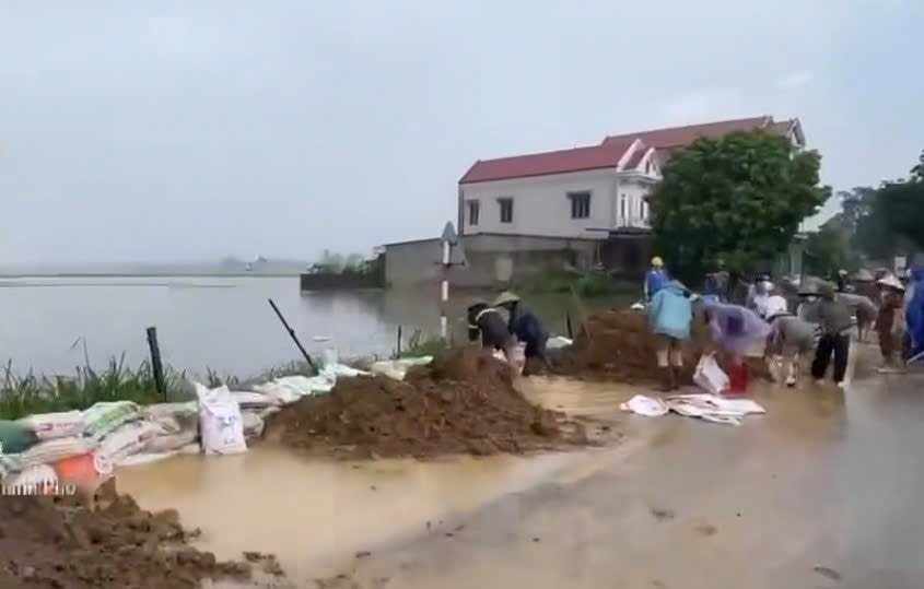Chính quyền địa phương và người dân xã Trung Giã tham gia đắp bờ bao chống nước lũ tràn vào khu dân cư. Ảnh: Bùi Ngân