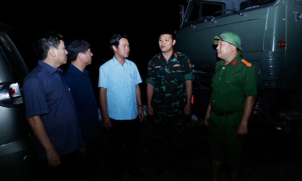 Đồng chí Phạm Đức Luận và Lê Xuân Lợi động viên các chiến sĩ lực lượng vũ trang tham gia chống lũ tại xã Hợp Thịnh.