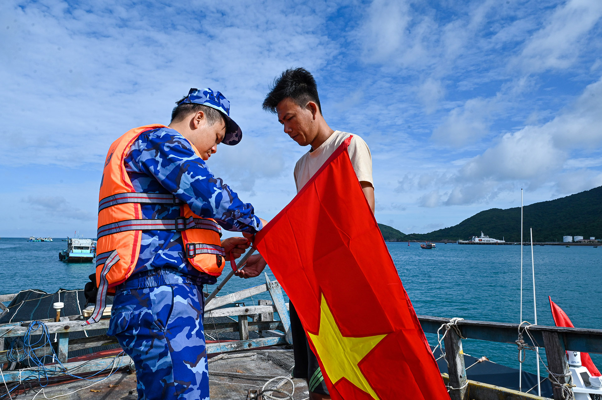 Chiến sĩ Cảnh sát biển cùng người dân treo cờ Tổ quốc