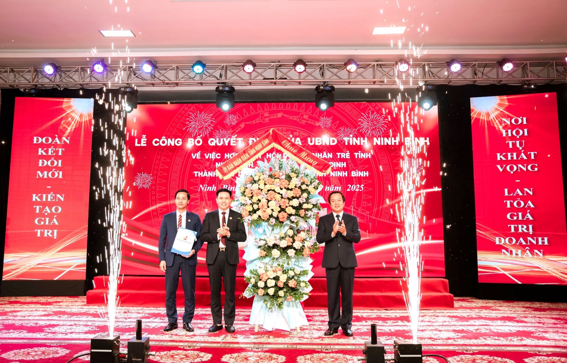 Chủ tịch UBND tỉnh Ninh Bình Phạm Quang Ngọc (bìa phải) tặng hoa và trao quyết định hợp nhất Hội Doanh nhân trẻ Ninh Bình, Hà Nam và Nam Định, chính thức thành lập Hội Doanh nhân trẻ tỉnh Ninh Bình