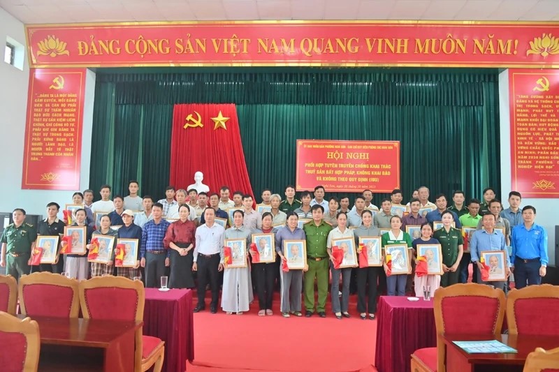 Ban Chỉ huy Biên phòng CKC Nghi Sơn và lãnh đạo phường Nghi Sơn trao Cờ Tổ quốc và ảnh Bác Hồ cho ngư dân.