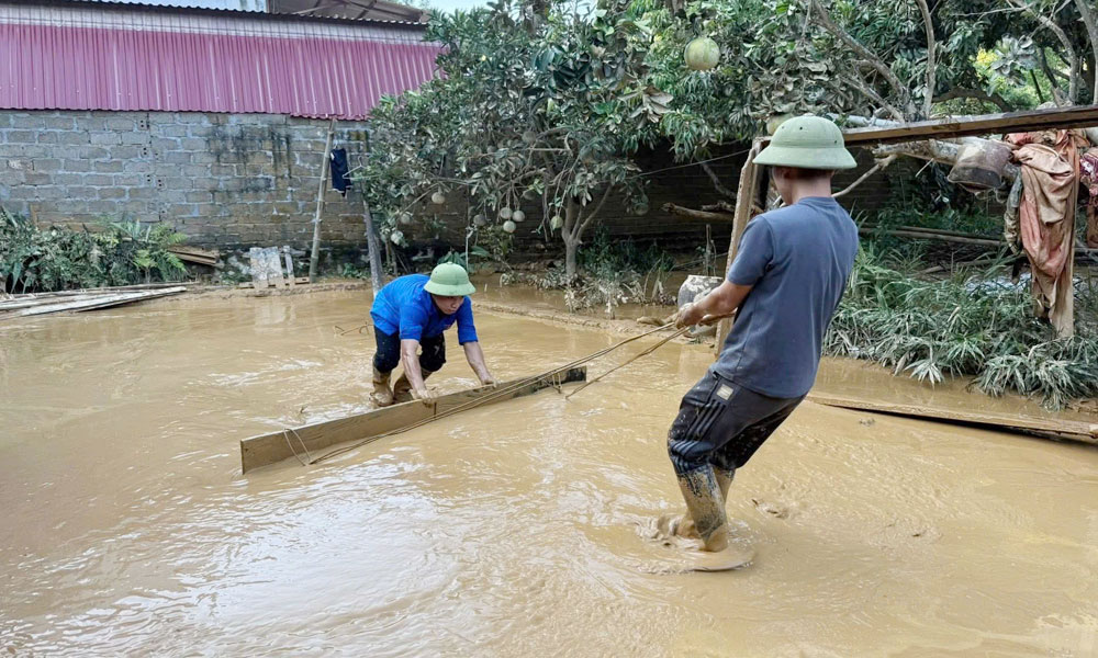 Đoàn viên thanh niên xã Xuân Lương giúp bà con hót dọn bùn đất, vệ sinh môi trường.