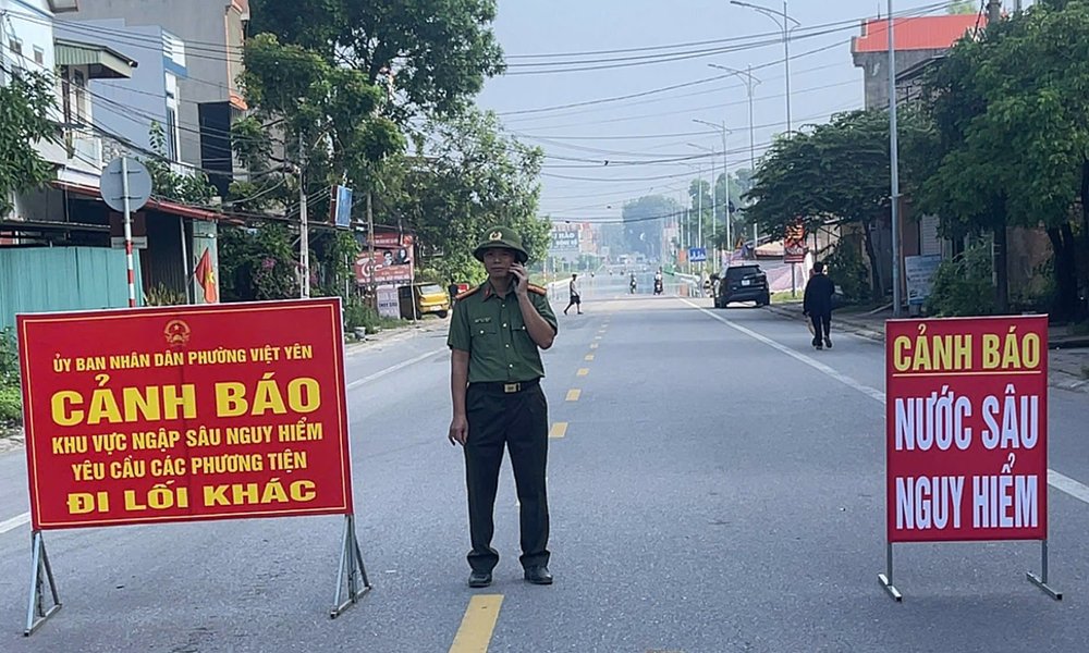 Lực lượng chức năng trực gác tại đường tỉnh 298 có mực nước sâu nguy hiểm.