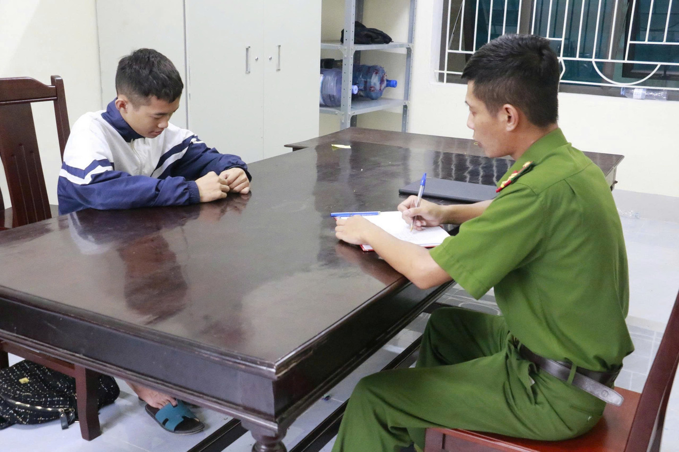 Công an lấy lời khai một đối tượng trong nhóm