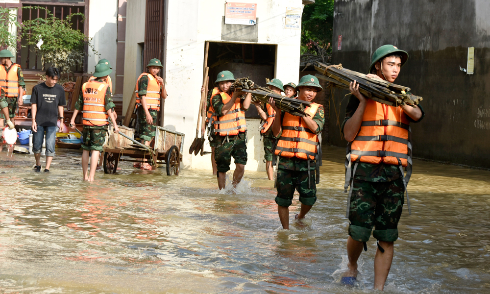 Chiến sĩ Sư đoàn 325 hỗ trợ vận chuyển đồ đạc cho một số hộ dân.