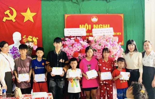 Bà Phạm Thị Hạnh (bìa trái) trao quà hỗ trợ trẻ em ở xã Tuy Phước Tây. Ảnh: King dom.