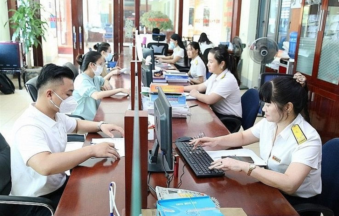 Công chức Thuế tỉnh Đồng Tháp hướng dẫn người dân làm thủ tục nộp thuế. Ảnh: KT