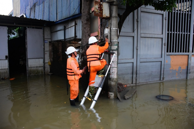 Công nhân EVNHANOI kiểm tra thiết bị điện tại khu vực ngập úng thuộc xã Trung Giã