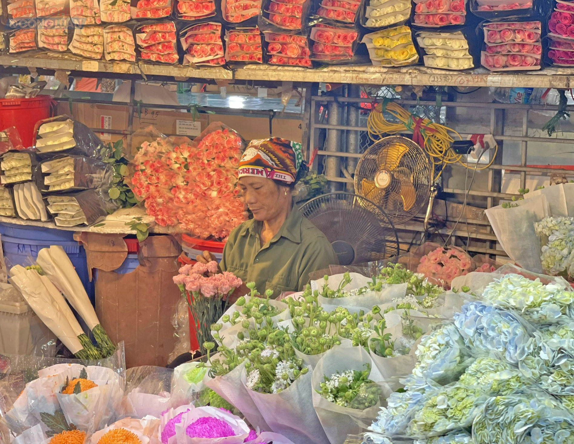 Tiểu thương thoăn thoắt bó hoa trong ánh đèn vàng buổi sớm. Tiểu thương thoăn thoắt bó hoa trong ánh đèn vàng buổi sớm.