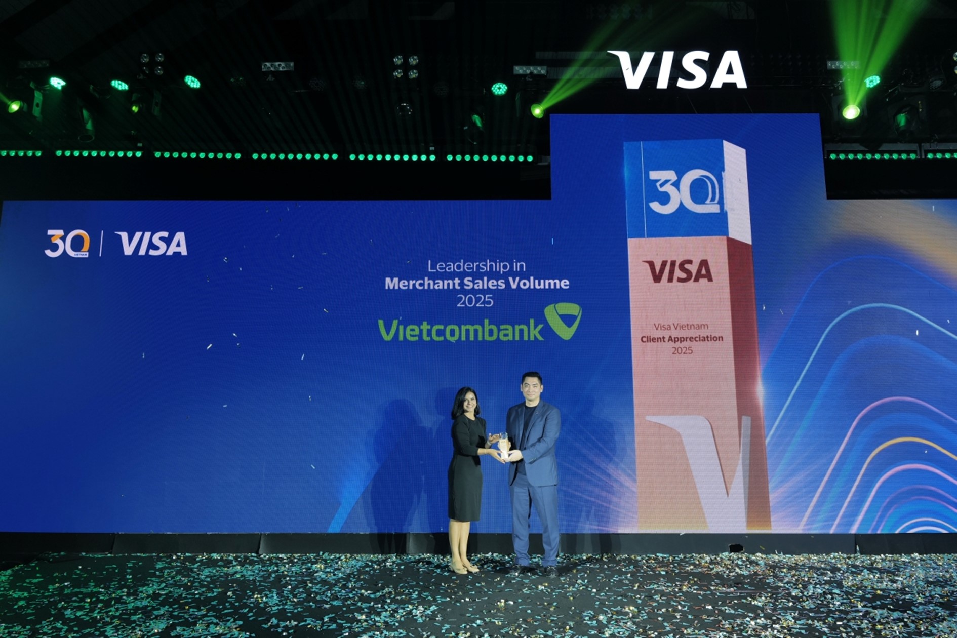 Đại diện Vietcombank, ông Trần Văn Thành - Phó Trưởng Phòng Phát triển Kênh số và Đối tác nhận giải thưởng “Leadership in Merchant Sales Volume – Ngân hàng dẫn đầu về doanh số thanh toán tại đơn vị chấp nhận thẻ năm 2025” từ đại diện Visa