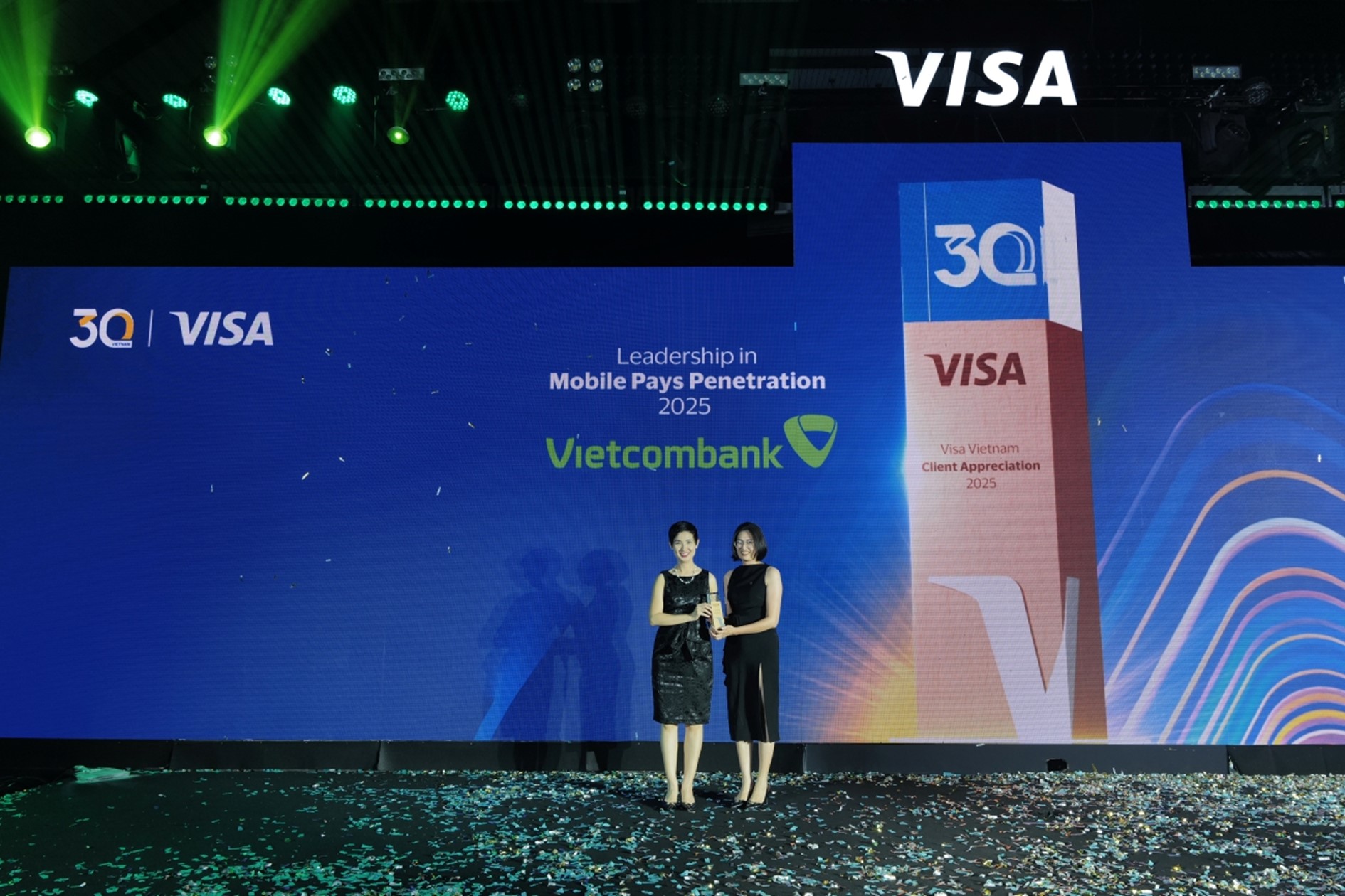 Đại diện Vietcombank, bà Lê Hồng Vân - Phó Giám đốc phụ trách Trung tâm Đổi mới Sáng tạo (bên phải) nhận giải thưởng “Leadership in Mobile Pays Penetration – Ngân hàng dẫn đầu về tần suất giao dịch qua ví điện tử năm 2025” từ đại diện Visa