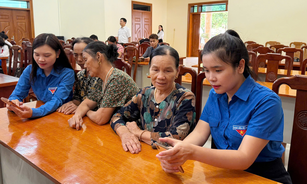 Đoàn viên thanh niên phường Tiền Phong hướng dẫn người dân sử dụng dịch vụ công trực tuyến.