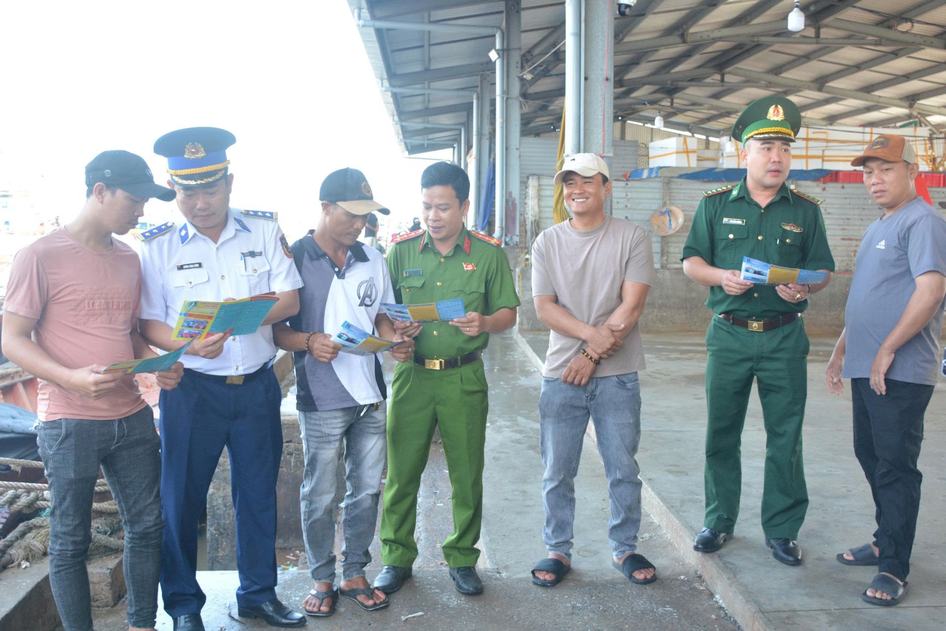 Các lực lượng tuyên truyền pháp luật đến ngư dân bằng tờ rơi
