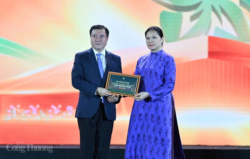 Bà Hà Thị Nga - Phó Chủ tịch Ủy ban Trung ương Mặt trận Tổ quốc Việt Nam tiếp nhận các khoản quyên góp ủng hộ đồng bào bị ảnh hưởng bão lũ, thiên tai của Bộ Công Thương từ Thứ trưởng Nguyễn Sinh Nhật Tân. Ảnh: Nam Nguyễn.