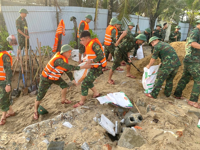 Các cán bộ, chiến sĩ khẩn trương gia cố bờ kè sạt lở