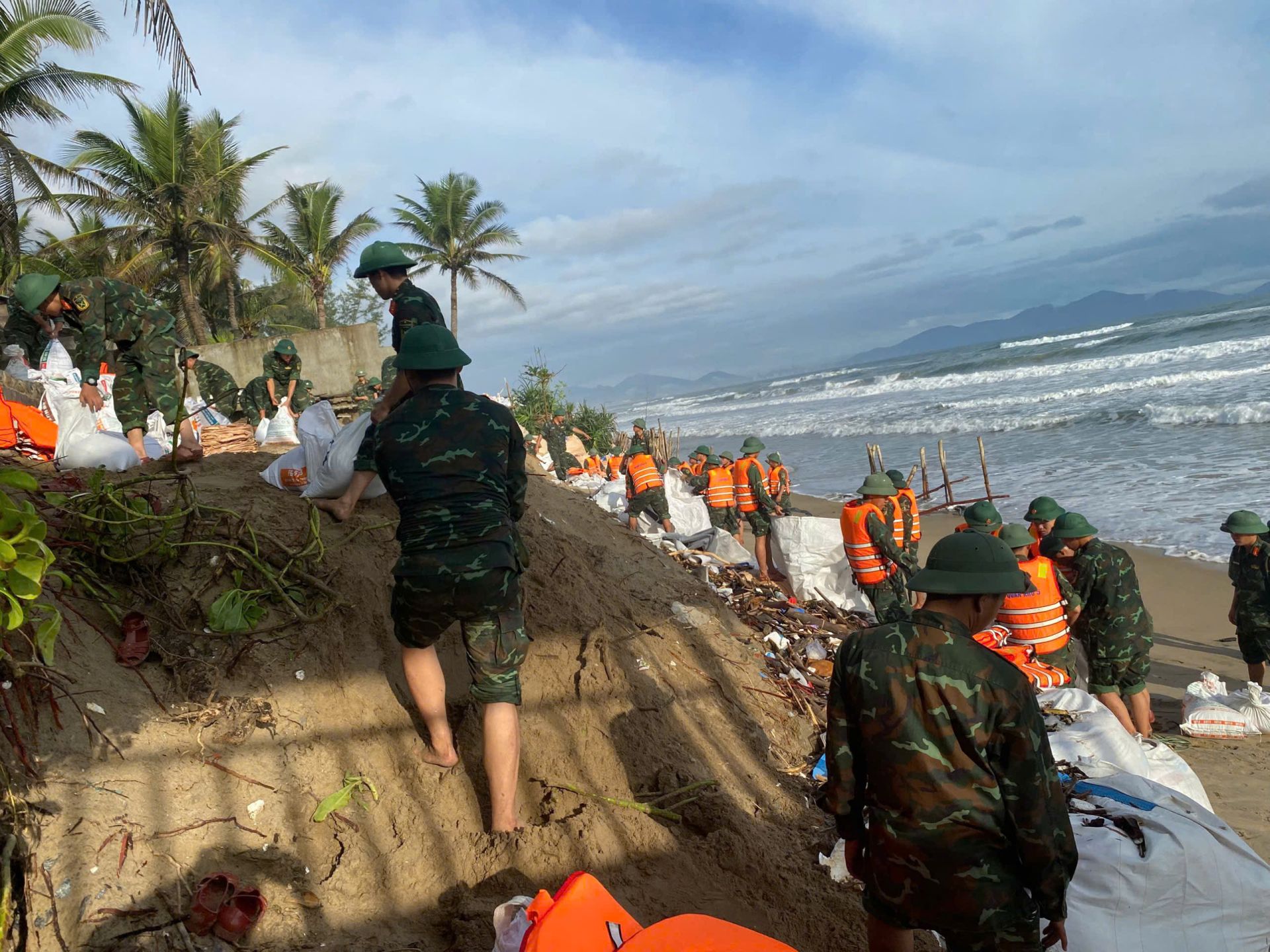 Lực lượng quân đội phối hợp gia cố tạm thời các điểm xói lở sâu.