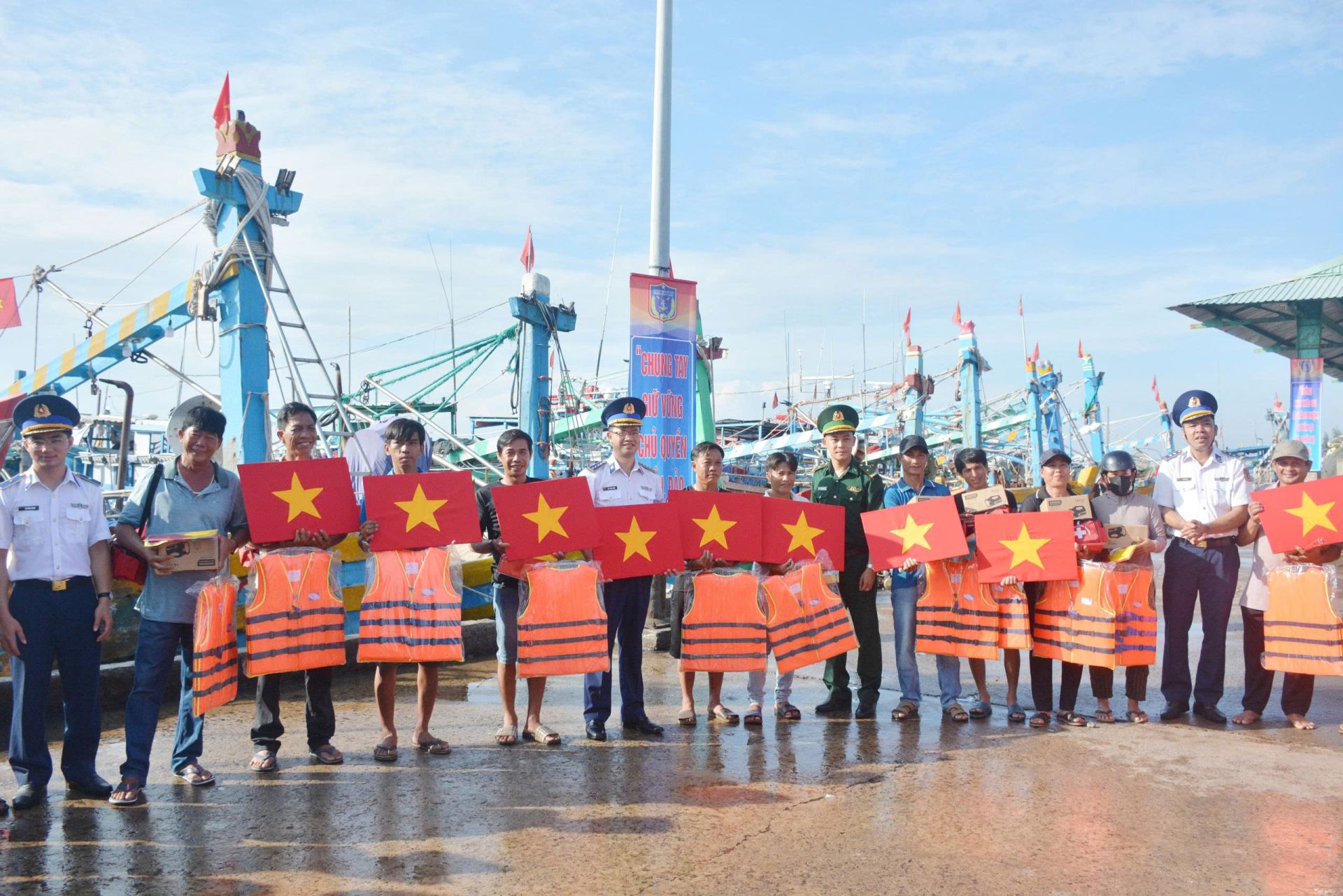 Đoàn công tác trao cờ Tổ quốc, áo phao, túi thuốc và đèn pin tặng ngư dân.