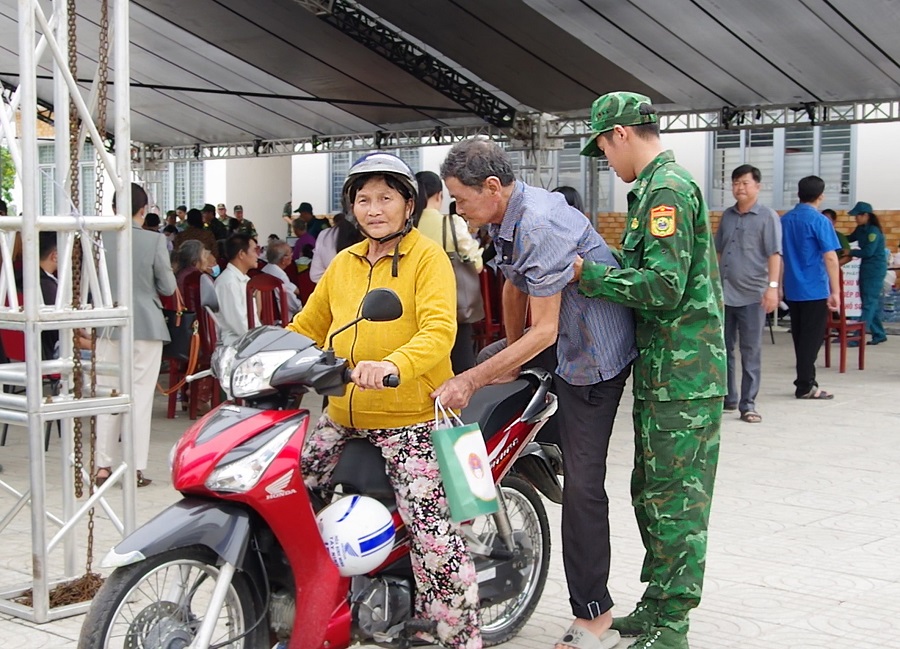 Cán bộ, chiến sĩ Bộ đội Biên phòng hỗ trợ người dân đến khám bệnh