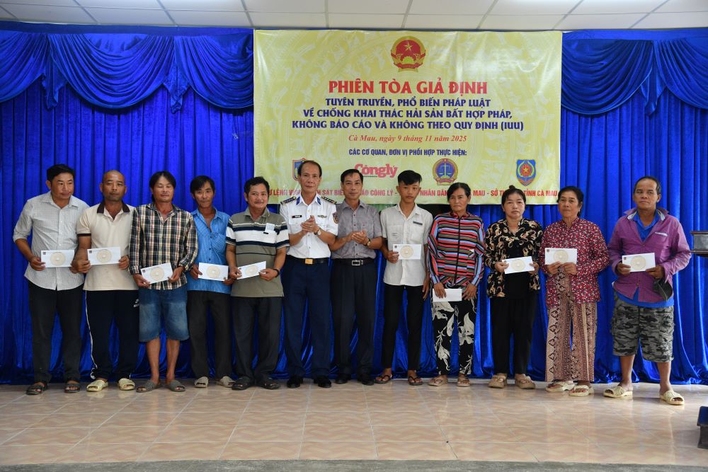 Đại diện BTL Vùng Cảnh sát biển 4 và lãnh đạo các đơn vị phối hợp trao quà; tặng Cờ Tổ quốc, ảnh Bác Hồ, túi thuốc y tế cho bà con ngư dân tại xã Khánh Lâm và phường Hiệp Thành