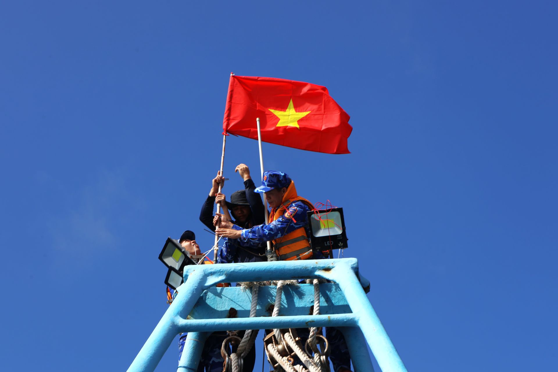 Cán bộ chiến sĩ cùng ngư dân treo cờ Tổ Quốc