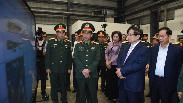 Thủ tướng Phạm Minh Ch&iacute;nh nghe giới thiệu về một số sản phẩm c&ocirc;ng nghiệp quốc ph&ograve;ng. (Ảnh: TRẦN HẢI)