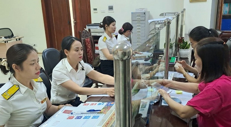 Công chức Thuế tỉnh Sơn La hướng dẫn người dân làm thủ tục nộp thuế. Ảnh: KT Công chức Thuế tỉnh Sơn La hướng dẫn người dân làm thủ tục nộp thuế. Ảnh: KT