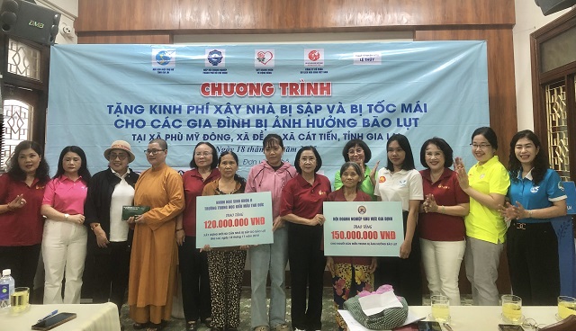 Ban tổ chức trao bảng tượng trưng hỗ trợ các gia đình có nhà bị sập và bị tốc mái. Ảnh: VH