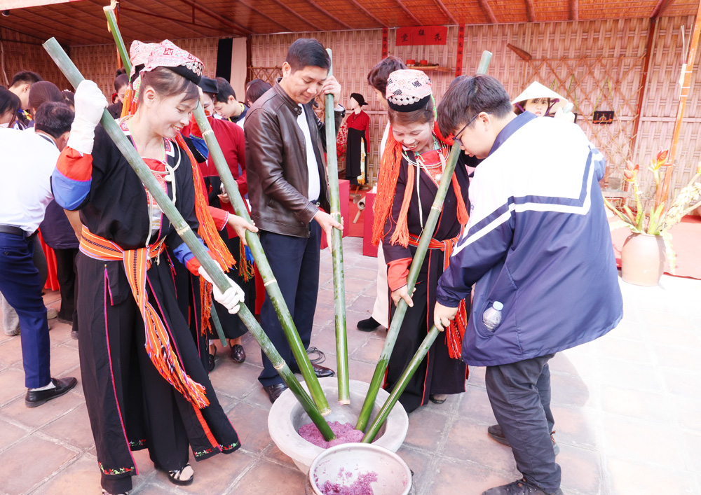 Đại biểu v&agrave; c&aacute;c em học sinh trải nghiệm l&agrave;m b&aacute;nh của đồng b&agrave;o d&acirc;n tộc thiểu số.